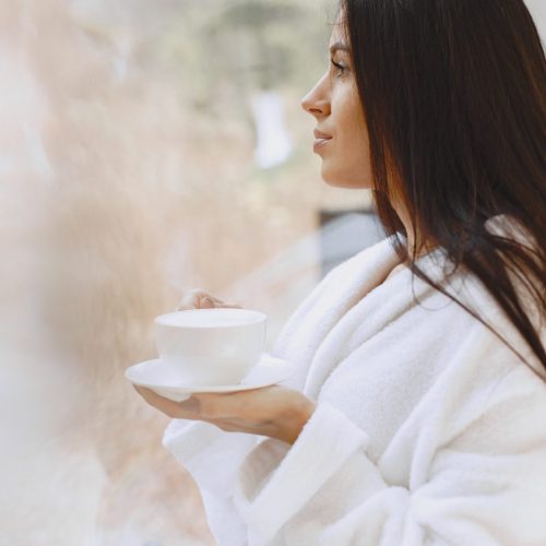 Good morning. Woman drinks coffe. Lady by the window.
